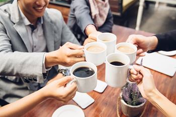 A group of people sharing a moment over cups of coffee.